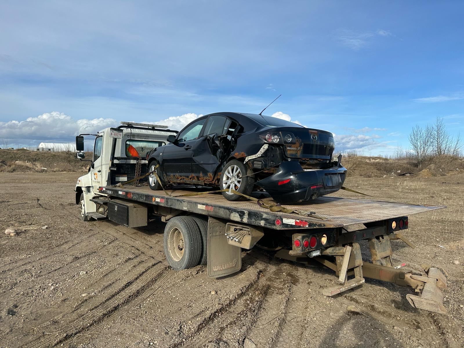 tow truck Fort McMurray - Cool Ride Towing flatbed assisting stranded driver after car accident on Fort McMurray road