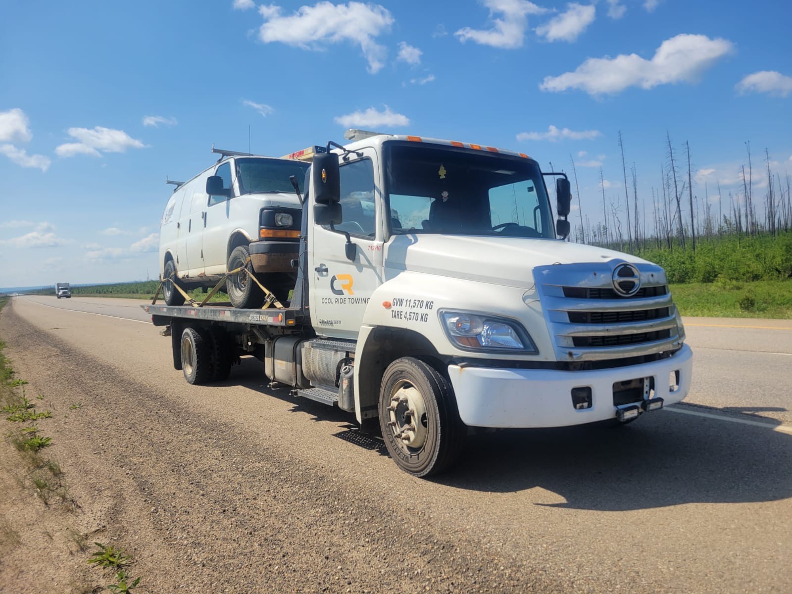 flatbed tow truck Fort McMurray - Cool Ride Towing transporting vehicle on Alberta highway for emergency towing service